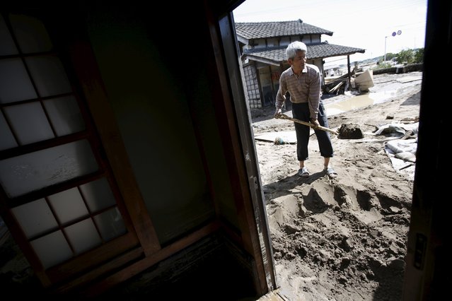 Local resident Toshiichi Nakazawa, 75, removes mud and debris around the entrance of his house at a residential area flooded by the Kinugawa river, caused by typhoon Etau, in Joso, Ibaraki prefecture, Japan, September 11, 2015. (Photo by Issei Kato/Reuters)