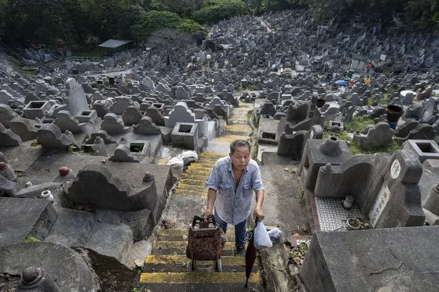 A man walks up the steep steps at the Diamond Hill cemetery during the Chung Yeung Festival in Hong Kong on October 4, 2022. The annual Chung Yeung Festival, citizens visit the graves of deceased relatives, clean the tombs while leaving offerings and flowers in remembrance and respect. (Photo by Miguel Candela/Anadolu Agency via Getty Images)