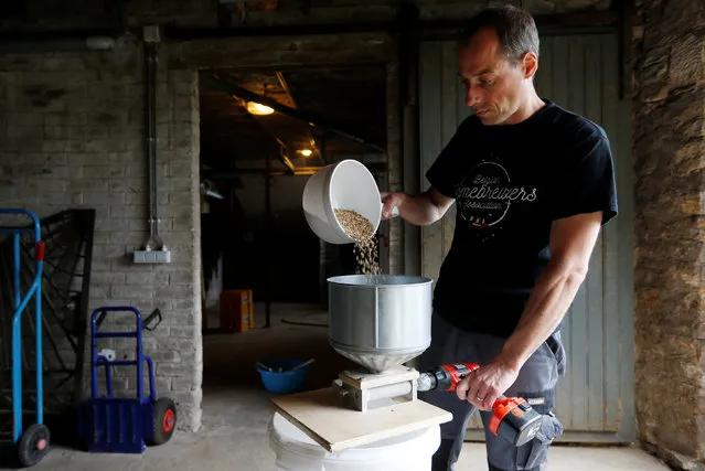 Axel Henrard, psychologist and President of the Belgian Homebrewers association, mills malt in a former barn of his house as he starts making his own beer in Attert, Belgium, August 11, 2016. (Photo by Francois Lenoir/Reuters)