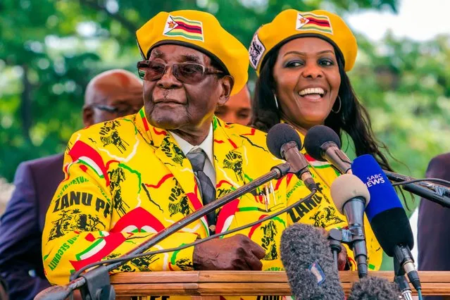 This file photo taken on November 8, 2017 shows .Zimbabwe' s President Robert Mugabe (L) addressing party members and supporters gathered at his party headquarters to show support to Grace Mugabe (R) becoming the party' s next Vice President after the dismissal of Emerson Mnangagwa. Several tanks were seen moving near the Zimbabwean capital Harare on November 14, 2017 witnesses told AFP, a day after the army warned it could intervene over a purge of ruling party officials. (Photo by Jekesai Njikizana/AFP Photo)
