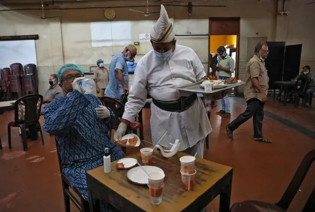 A waiter wearing a protective face mask serves a customer inside the Indian Coffee House after it was re-opened, after authorities eased lockdown restrictions that were imposed to slow the spread of the coronavirus disease (COVID-19), in Kolkata, India, July 2, 2020. (Photo by Rupak De Chowdhuri/Reuters)