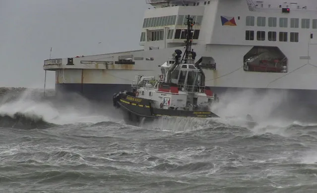 In this grab taken from video, a tug boat attempts to tow The Pride of Kent ferry, in Calais, France, Sunday, December 10, 2017.  Authorities prepared the emergency evacuation of a ferry carrying 313 people that ran aground at the French port city of Calais Sunday interrupting boat traffic across the English Channel, according to authorities. (Photo by AP Photo)