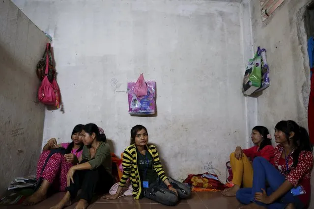 Garment workers sit on the floor of their apartment during a lunch break in a suburb of Phnom Penh in this June 26, 2013 file photo. Cambodia is expected to set a new minimum wage for garment workers this week. (Photo by Damir Sagolj/Reuters)