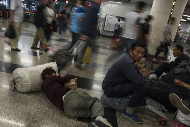 Migrant workers wait on the floor of the Beijing West Railway Station on May 26, 2016. Migrant labor continues to pour into Beijing and China's cities as economic opportunities dry up in rural areas. National surveys say that migrant workers make up more than one third of China's workforce. (Photo by Michael Robinson Chavez/The Washington Post)