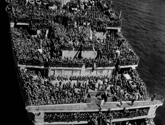 In this image provided by the U.S. Coast Guard, U.S. troops returning from Europe pack the decks of the British luxury liner-turned-troopship HMS Queen Mary as she steams into New York Harbor June 20, 1945 with some 14,000 troops aboard.  This was the ship's first voyage to America since V-E Day. (Photo by AP Photo/U.S. Coast Guard)