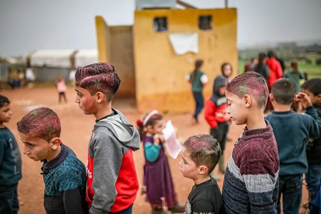 Children wait in line as a group of barbers shave the children for free at Azraq Refugee Camp to celebrate after Morocco defeats Portugal 1-0 in the 2022 FIFA World Cup quarter-final match, Morocco advanced to the semi-finals on December 13, 2022 in Idlib, Syria. (Photo by Muhammed Said/Anadolu Agency via Getty Images)