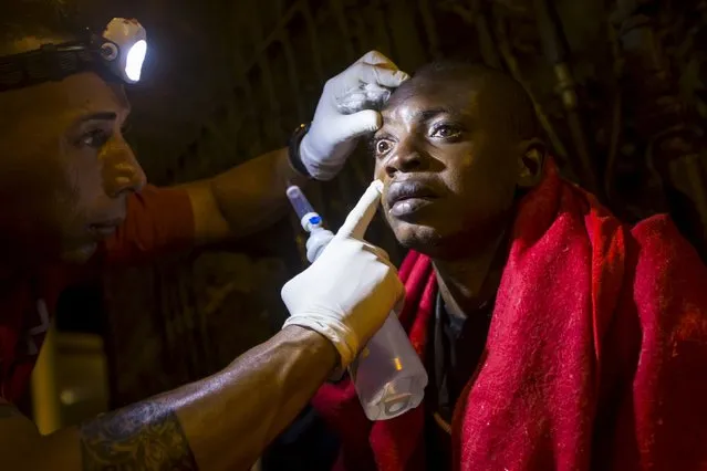 An African migrant is helped by a Red Cross worker after arriving at Maspalomas beach on the Canary Island of Gran Canaria, Spain October 8, 2015. Some 41 African migrants arrived in a fishing boat on their way to European soil from Africa, Spanish police said. (Photo by Borja Suarez/Reuters)