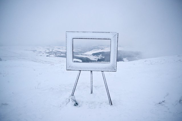 Fog and snow surround an art installation, giving a pictured-framed view over the valley beneath, at the summit of Holme Moss in the Peak District, in northern England on January 7, 2025, after snow and rain continued to fall across parts of the United Kingdom. (Photo by Oli Scarff/AFP Photo)