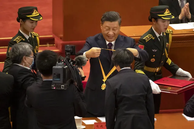 Chinese President Xi Jinping, rear center, presents a medal to an honoree at an event to honor some of those involved in China's fight against COVID-19 at the Great Hall of the People in Beijing, Tuesday, September 8, 2020. (Photo by Mark Schiefelbein/AP Photo)