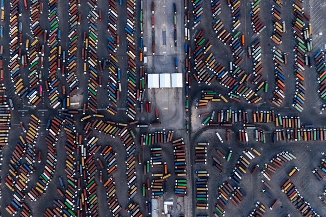This aerial view shows trucks towing shipping containers at the port of Umm Qasr in Iraq's southern city of Basra on May 26, 2025. (Photo by Hussein Faleh/AFP Photo)