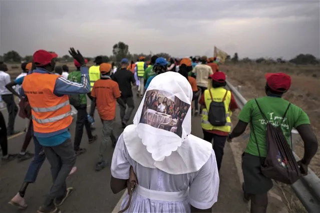 A sister wears headwear showing a picture of The Last Supper, as she and a group of the Catholic faithful from the town of Rumbek arrive after walking for more than a week to reach the capital for the visit of Pope Francis, in Juba, South Sudan Thursday, February 2, 2023. Pope Francis is due to travel to South Sudan later this week on the second leg of a six-day trip that started in Congo, hoping to bring comfort and encouragement to two countries that have been riven by poverty, conflicts and what he calls a “colonialist mentality” that has exploited Africa for centuries. (Photo by Ben Curtis/AP Photo)