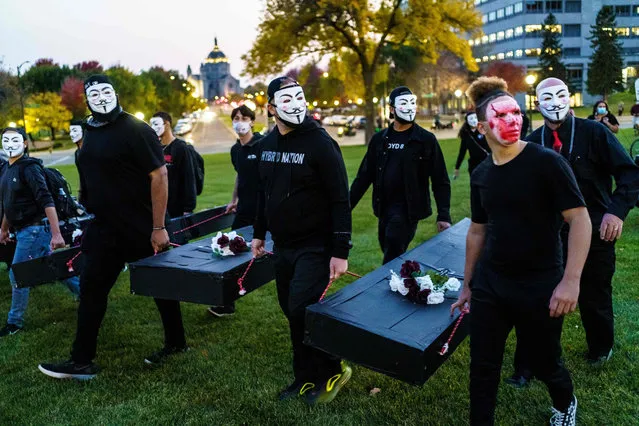 Relatives of those killed by the police carry cardboard coffins as they march during a demonstration after the release on bail of former police officer, Derek Chauvin, in Saint Paul, Minnesota, on October 8, 2020. The police officer charged with killing George Floyd, the African American whose death sparked a mass protest movement, was released from a Minnesota jail on October 7 on $1 million bail. (Photo by Kerem Yucel/AFP Photo)
