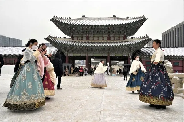 Women wearing traditional “Hanbok” dresses take pictures in the snow at the Gyeongbok Palace, the main royal palace during the Joseon Dynasty, and one of South Korea's well known landmarks in Seoul, South Korea, Thursday, January 26, 2023. (Photo by Ahn Young-joon/AP Photo)