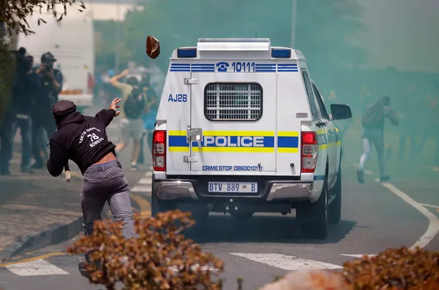 A student throws a rock at a South African police car during clashes over high tuition fees at Johannesburg's University of the Witwatersrand, South Africa, October 4, 2016. (Photo by Siphiwe Sibeko/Reuters)