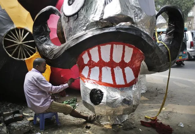 An Indian artist paints an effigy of the ten-headed demon god Ravana in preparation for the upcoming Dussehra Hindu festival in New Delhi, India, Tuesday, October 4, 2016. The effigies will be burned during the festival, symbolizing the victory of good over the evil. (Photo by Altaf Qadri/AP Photo)