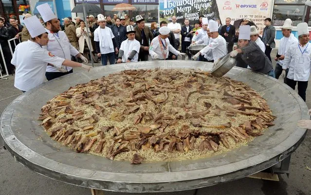 Kyrgyz chefs cook the largest noodles with meat in the “Besh Barmak” national style, including 117-metres of horse sausage in the Kyrgyz “Chuchuk” style, as they attempt a Guinness Record on March 11, 2018 in Bishkek. The total weight of the “Besh Barmak” was 1464 kilo, organizers said. (Photo by Vyacheslav Oseledko/AFP Photo)