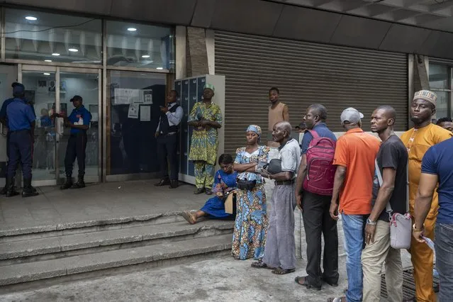 Customers who had waited for many hours stand outside a bank in the slim hope of being able to withdraw some cash, in Lagos, Nigeria Thursday, February 23, 2023. Voters will elect a new leader Saturday after President Muhammadu Buhari's final term ends, with 18 candidates vying to lead a country facing a series of struggles – the newest and most pressing being a shortage of cash. (Photo by Ben Curtis/AP Photo)