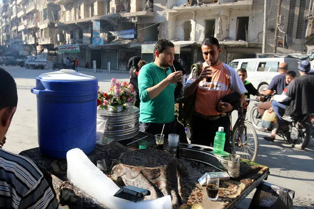 Men drink a traditional liquorice drink in the beseiged rebel held area of Aleppo, Syria October 8, 2016. (Photo by Abdalrhman Ismail/Reuters)