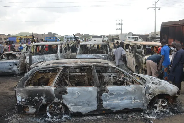 People stand next to burned cars after a tanker exploded on Lagos-Ibadan Expressway on November 7, 2020 in Ogun state killing two people in a huge blaze. Multiple vehicles were engulfed in a fire that started on Saturday morning along the Kara Bridge section of the Lagos-Ibadan Expressway, The incident led to heavy traffic on that section of the expressway on Saturday morning. (Photo by Olukayode Jaiyeola/NurPhoto via Getty Images)