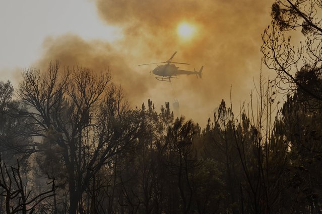 A helicopter drops water on a wildfire in Larouco, northwestern Spain, Wednesday, August 13, 2025. (Photo by Lalo R. Villar/AP Photo)