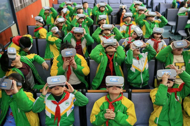 Primary school students wear virtual reality (VR) headsets inside a classroom in Xiangxi Tujia and Miao Autonomous Prefecture, Hunan province, China March 14, 2018. (Photo by Reuters/China Stringer Network)