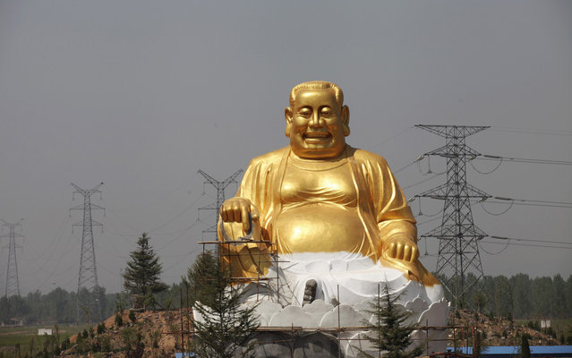 A statue is constructed at an amusement park in Luoyang, Henan province April 25, 2013. The statue is designed with its head resembling the amusement park owner's and its body structure resembling Buddha's. (Photo by Reuters/Stringer)