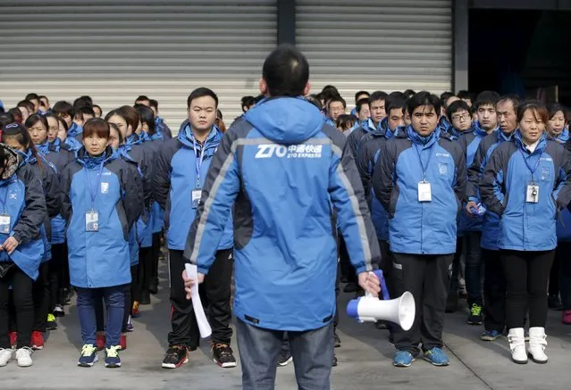 Workers listen to their line manager as he prepares them for the upcoming Singles Day shopping festival, at a sorting centre of Zhongtong (ZTO) Express, Chaoyang District, Beijing, November 8, 2015. (Photo by Jason Lee/Reuters)