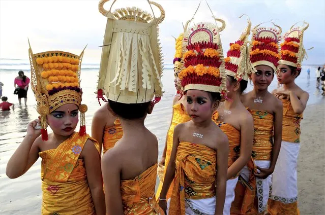 Children with traditional dress walk during the Melasti, a purification ceremony at Kuta beach, Bali, Indonesia on Sunday, March 19, 2023. The ritual, which is performed ahead of the Balinese Hindu's Day of Silence, is held to purify the universe from bad influences, bad deeds and bad thoughts. (Photo by Firdia Lisnawati/AP Photo)