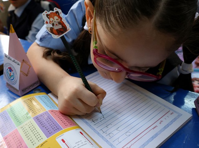 A student writes in her notebook on the first day of the new school term at a primary school in Baghdad, Iraq, on September 21, 2025. (Photo by Ahmed Saad/Reuters)