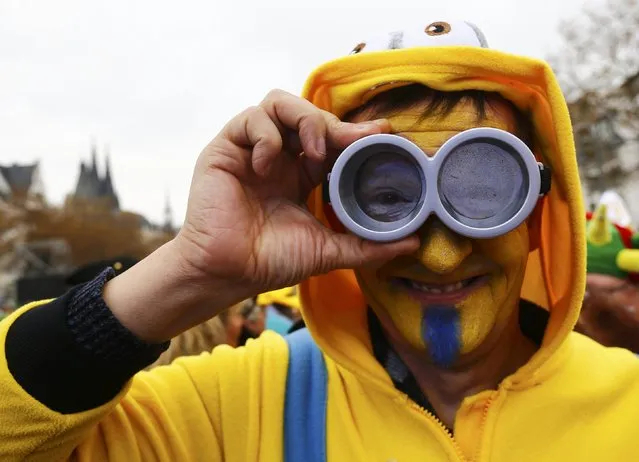 A carnival reveller looks through goggles at the start of the carnival season in Cologne November 11, 2015. (Photo by Wolfgang Rattay/Reuters)