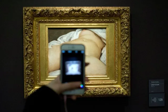In this February 12 2016 file photo, a visitor takes a picture of Gustave Courbet's 1866 “The Origin of the World”, at Musee d'Orsay museum, in Paris. She was a courtesan living from subsidies provided by rich men – but preferring the company of women – and ended her life as a very honorable patroness helping orphans. (Photo by Francois Mori/AP Photo)