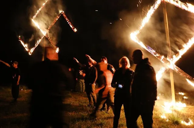 Members of the National Socialist Movement, one of the largest neo-Nazi groups in the US, hold a swastika burning after a rally on April 21, 2018 in Draketown, Georgia. Community members had opposed the rally in Newnan and came out to embrace racial unity in the small Georgia town. Fearing a repeat of the violence that broke out after Charlottesville, hundreds of police officers were stationed in the town during the rally in an attempt to keep the anti racist protesters and neo-Nazi groups separated. (Photo by Spencer Platt/Getty Images)