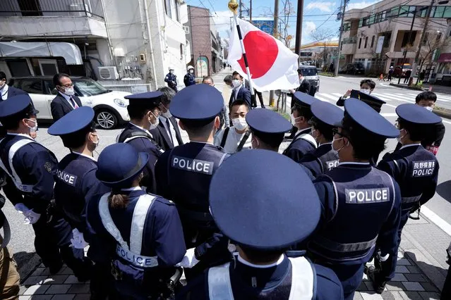A person holding a Japanese flag is surrounded by police officers at a street ahead of the G7 Foreign Ministers' Meeting Sunday, April 16, 2023, near Karuizawa station in Karuizawa, a resort town north of Tokyo. (Photo by Eugene Hoshiko/AP Photo)