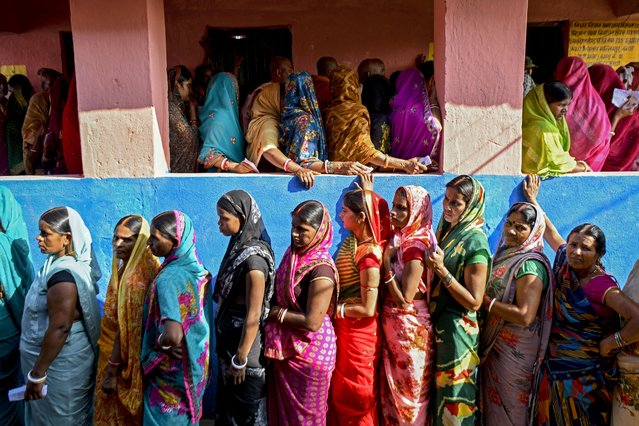 Women voters stand in queues to cast their ballots at a polling station during the first phase of voting for assembly elections on November 6, 2025, at the Raghopur constituency in the Vaishali district of the Indian state of Bihar. (Photo by Sachin Kumar/AFP Photo)