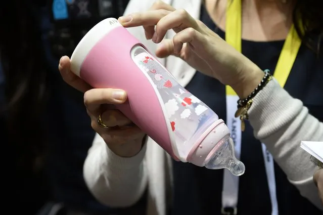 The Slow Control smart baby bottle is displayed at CES Unveiled, the opening event for the media preview days at the 2015 Consumer Electronics Show, January 4, 2015 in Las Vegas, Nevada. The smart baby bottle holder helps parents track how much and how fast their baby is drinking, providing feedback on how to hold properly to prevent babies from swallowing air. (Photo by Robyn Beck/AFP Photo)