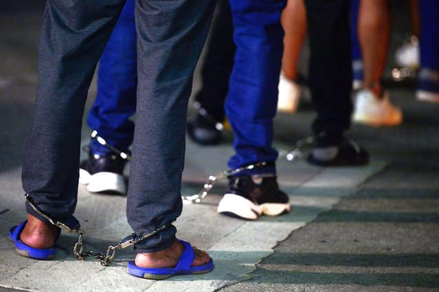 Colombian migrants stand in shackles as they prepare to enter a plane for deportation at the Marcos A. Gelabert de Albrook Airport in Panama City, Tuesday, August 20, 2024. (Photo by Agustin Herrera/AP Photo)
