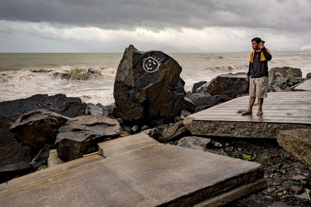 A resident makes a phone call as he stands on a highway destroyed by storm surges brought about by Super Typhoon Fung-wong on November 10, 2025 in Dipaculao, Aurora province, Philippines. Super Typhoon Fung-wong made landfall the previous evening in the Philippines, prompting the evacuation of nearly one million people and causing severe flooding, power outages, and disruptions across Luzon just days after the devastation of Typhoon Kalmaegi. (Photo by Ezra Acayan/Getty Images)