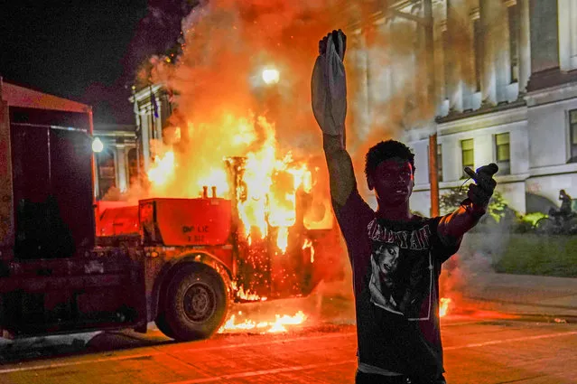 A protestor takes his turn posing in front of a burning garbage truck during a seconed night of unrest in the wake of the shooting of Jacob Blake by police officers, in Kenosha, Wisconsin, USA, 24 August 2020. According to media reports Jacob Blake, a black man, was shot by a Kenosha police officer or officers responding to a domestic distubance call on 23 August, setting off protests and unrest. Blake was taken by air ambulance to a Milwaukee, Wisconsin hospital and protests started after a video of the incident was posted on social media. (Photo by Tannen Maury/EPA/EFE)