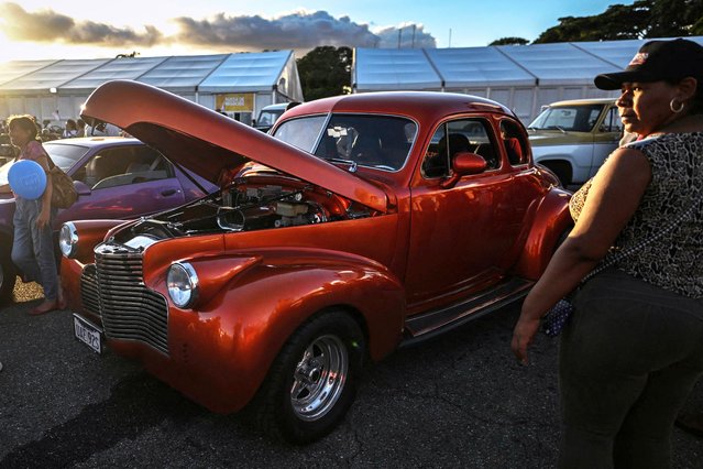 People look at a collection of vintage cars during the Expo Transporte event at the Francisco de Miranda Air Base in Caracas on December 7, 2025. (Photo by Juan Barreto/AFP Photo)