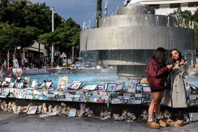 Israeli women stand at Dizengoff Square where pictures and memorabilia of hostages kidnapped during the deadly October 7, 2023 attack on Israel are displayed, amid the ongoing conflict in Gaza between Israel and Hamas, in Tel Aviv, Israel on November 20, 2024. (Photo by Nir Elias/Reuters)