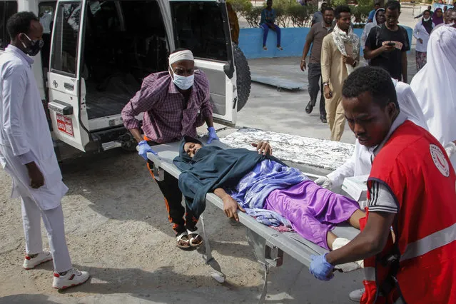 A woman who was wounded in a bombing is stretchered into a hospital in Mogadishu, Somalia, Saturday, February 13, 2021. (Photo by Farah Abdi Warsameh/AP Photo)