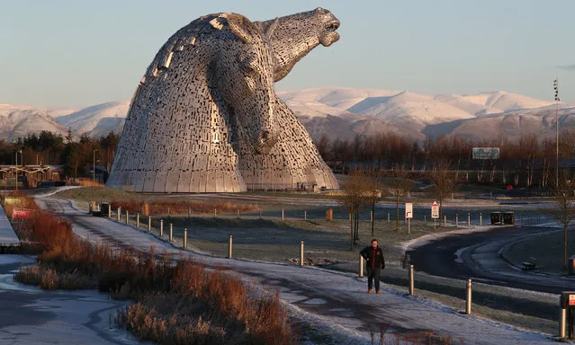 A man walks through the morning frost past the Kelpies in Falkirk, Central Scotland on January 8, 2021. (Photo by Andrew Milligan/PA Images via Getty Images)