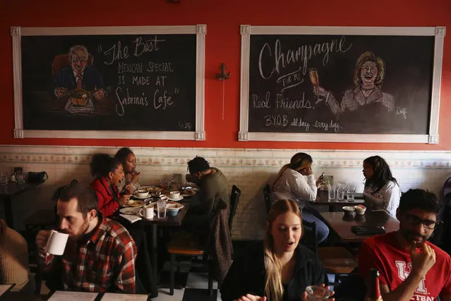 Campaign artwork featuring U.S. Democratic presidential nominee Hillary Clinton and U.S. Republican presidential nominee Donald Trump hangs on the wall above patrons of Sabrina's Cafe in Philadelphia, Pennsylvania, U.S., November 5, 2016. (Photo by Lucas Jackson/Reuters)
