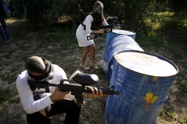 An Israeli couple attend a “trash the dress” event at a paint-ball venue in the southern Israeli city of Ashdod, December 25, 2015. (Photo by Amir Cohen/Reuters)