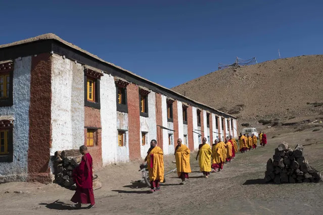 In this photograph taken on July 9, 2018, Indian Buddhist monks leave on procession during a morning 'puja' at Tnagyud Gompa monastery in Komik in Spiti Valley in the northern state of Himachal Pradesh. (Photo by Xavier Galiana/AFP Photo)