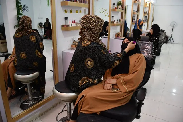 An Afghan beautician applies makeup to a client at a beauty salon in Mazar-i-Sharif on July 5, 2023. Afghanistan's Taliban authorities have ordered beauty parlours across the country to shut within a month, the vice ministry confirmed July 4, the latest curb to squeeze women out of public life. (Photo by Atif Aryan/AFP Photo)
