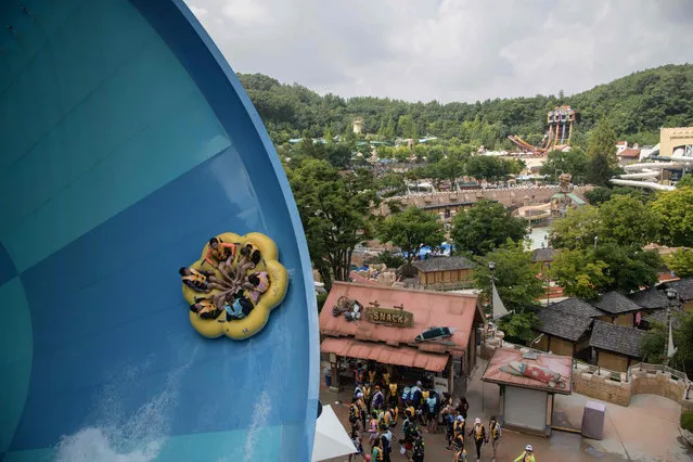 People ride a water slide at the Caribbean Bay water park in Yongin, outside Seoul, South Korea on August 6, 2018. (Photo by Ed Jones/AFP Photo)