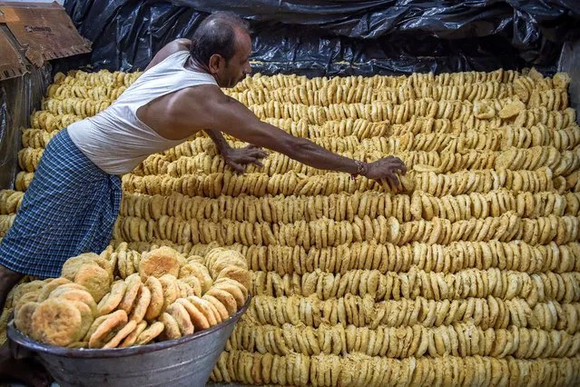 A worker at a confectionary arranges a traditional sweetmeat locally known as “Khaja” which are popularly sold ahead of Hindu festival of ‘Nag Panchami’, at a workshop in Ahmedabad on August 31, 2023. (Photo by Sam Panthaky/AFP Photo)
