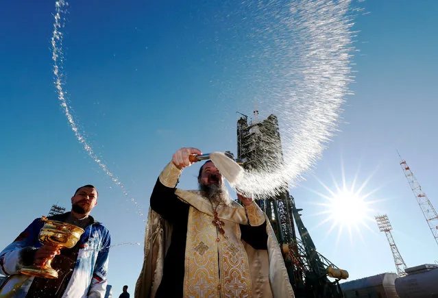 An Orthodox priest conducts a blessing in front of the Soyuz MS-10 spacecraft set on the launchpad ahead of its upcoming launch, at the Baikonur Cosmodrome in Kazakhstan, October 10, 2018. (Photo by Shamil Zhumatov/Reuters)