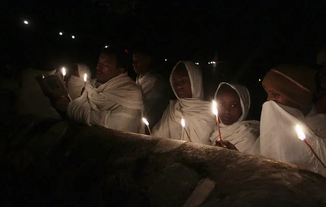 Ethiopian Orthodox faithful hold candles as they attend the eve-prayers during the Timket celebration to commemorate the baptism of Jesus Christ by John the Baptist in the River Jordan, in Gondar, Ethiopia, January 20 2016. (Photo by Tiksa Negeri/Reuters)